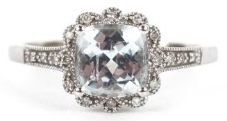 A 9ct white gold cushion cut topaz ring with diamond set shoulders, total diamond weight