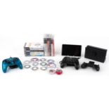 A Nintendo Switch games console with controllers together with two vintage Tamagotchi Connections