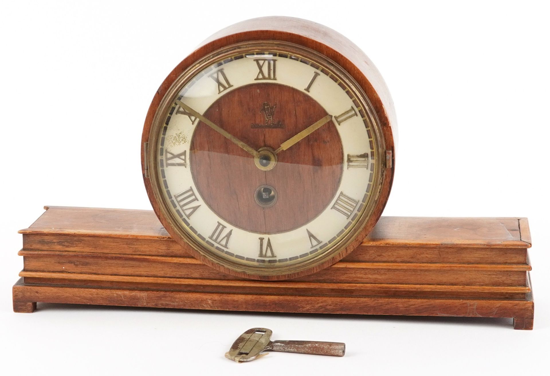 An Art Deco walnut mantle clock having Roman numerals and indistinct ...