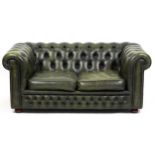Green leather button back Chesterfield two seater settee, 69cm H x 155cm W x 90cm D.