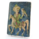 Antique Persian pottery tile hand painted with a figure on horseback with falcon, 22cm x 15cm.