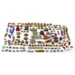 Collection of militaria including uniform buttons, cap badges and ammunition shell cases, various