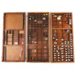 Three vintage wooden printer's block trays with a collection of thimbles and objects, the trays 82cm