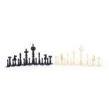 19th century carved bone half stained chess set, the largest piece 11cm high