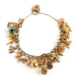 Charm bracelet, with 19 charms comprising of a frog stamped 18 ct, a plane, musical instruments,
