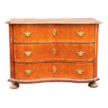 A mid 18th century oak chest of drawers, probably South German, of serpentine outline,