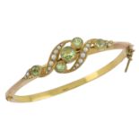 A late Victorian gold, peridot and split pearl hinged bangle