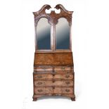 A 20th Century reproduction walnut veneered bureau bookcase in the George II style, with twin swan