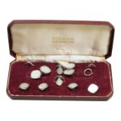 A cased mother of pearl mounted base metal eight piece dress stud set.