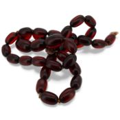 A simulated amber bead necklace, composed of deep cherry-coloured plastic/resin beads measuring