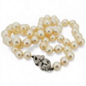 A single strand graduated cultured pearl necklace, with a diamond cluster set white metal clasp,