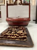 A Chinese red lacquered picnic box, and a figurative carved giltwood panel, picnic box 37cm diam.