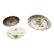 An 18th century German faience dish and two 19th century French faience dishes/plates, largest 39cm