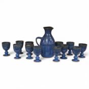 A Canterbury pottery, blue glaze jug and twelve goblets, jug 28cm high