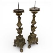 A pair of 17th century Italian embossed brass pricket candlesticks, overall 45cm high