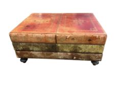 A gilt tooled leather covered three drawer coffee table modelled as a stack of books, width 90cm,