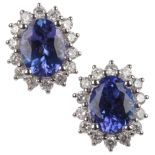 A pair of tanzanite and diamond stud earrings, each of cluster design, centring on oval tanzanites