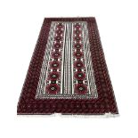 A Bokhara-style wool runner, the ivory field with twin columns of octagonal gul motifs within