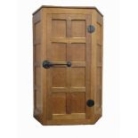 MOUSEMAN: WORKSHOP OF ROBERT THOMPSON (KILBURN): A PANELLED OAK CORNER CUPBOARD with an adzed top,
