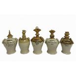 FIVE 19TH & EARLY 20TH CENTURY STONEWARE MONEY BANKS comprising one with a jug finial, impressed 'B.