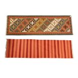 A lot comprising a multicoloured Kilim runner with allover geometric design within green and red
