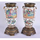 A PAIR OF ANTIQUE CHINESE CANTON FAMILLE ROSE BRONZE OIL LAMP BASES. 29 cm high.