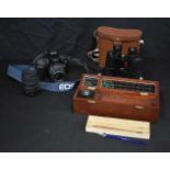 A Canon EOS 1000F camera and lens together with a cased pair of Wray binoculars and a contemporary