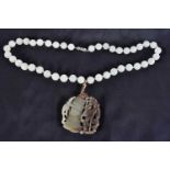 A CHINESE QING DYNASTY JADE NECKLACE. 66 cm long, pendant 5.25cm x 5.25cm.