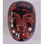 A FINE 19TH CENTURY JAPANESE MEIJI PERIOD NEOGRO LACQUER NETSUKE formed as a mask. 5 cm x 3.5 cm.