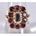 AN EARLY VICTORIAN YELLOW METAL GARNET AND PEARL RING. 6.2 grams. S.