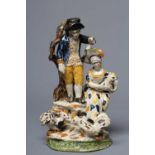 A STAFFORDSHIRE POTTERY COCKFIGHTING GROUP, early 19th century, modelled as a man wearing a blue