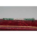 AN ART DECO TIE PIN, the seven small diamonds point set between fourteen small emeralds to a plain
