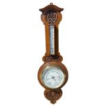 A carved oak aneroid barometer. 93cm h.