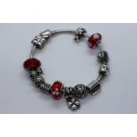 A SILVER "PANDORA" BRACELET WITH MOST CHARMS MARKED 925 ALE.