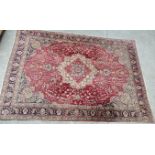 A LARGE TABRIZ PERSIAN STYLE RUG ON A RED GROUND 354 X 242CM.