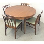 A MID CENTURY "G-PLAN" EXTENDING DINING TABLE AND FOUR MATCHING CHAIRS.