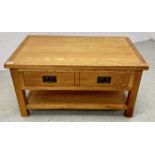A MODERN TWO DRAWER OAK COFFEE TABLE.