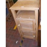 A stripped pine cupboard with asymmetrical opening