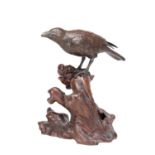 A MEIJI PERIOD JAPANESE BRONZE MODEL OF A CROW ON A CARVED ROOT WOOD STAND