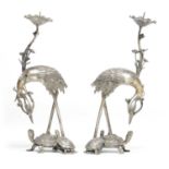 A PAIR OF MEIJI PERIOD JAPANESE WHITE METAL CANDLESTICKS FORMED AS CRANES STANDING ON TORTOISES