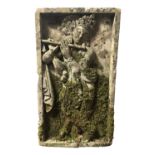 A CARVED STONE RELIEF PANEL OF A FLUTE-PLAYING DEITY