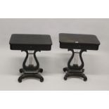 A PAIR OF REGENCY STYLE EBONISED WORK TABLES, with rising tops, compartmented interior on lyre
