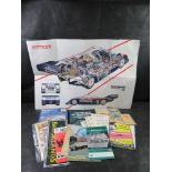 A collection of vintage automotive literature including Rothmans Porsche 956 cutaway poster,