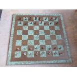 A large fold over brass covered chess board 100cm x 100cm with chess set
