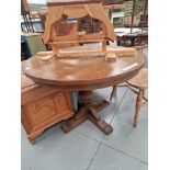A vintage oak extending pedestal dining table, the demilune ends and folding leaves on a baluster