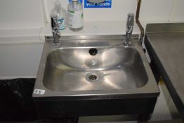 A stainless steel hand wash sink together with soap dispenser and hand towel dispenser