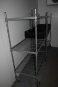 Four stainless steel storage racks on casters, of varying designs and heights