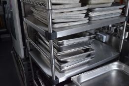 A large quantity of stainless steel trays, baskets etc