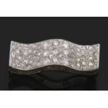 An early 20th century diamond brooch, the rectangular wave shape brooch set with round brilliant and