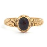 A 19th century 18ct mourning ring, with oval garnet in rubover mount with closed back, 8.5mm long,